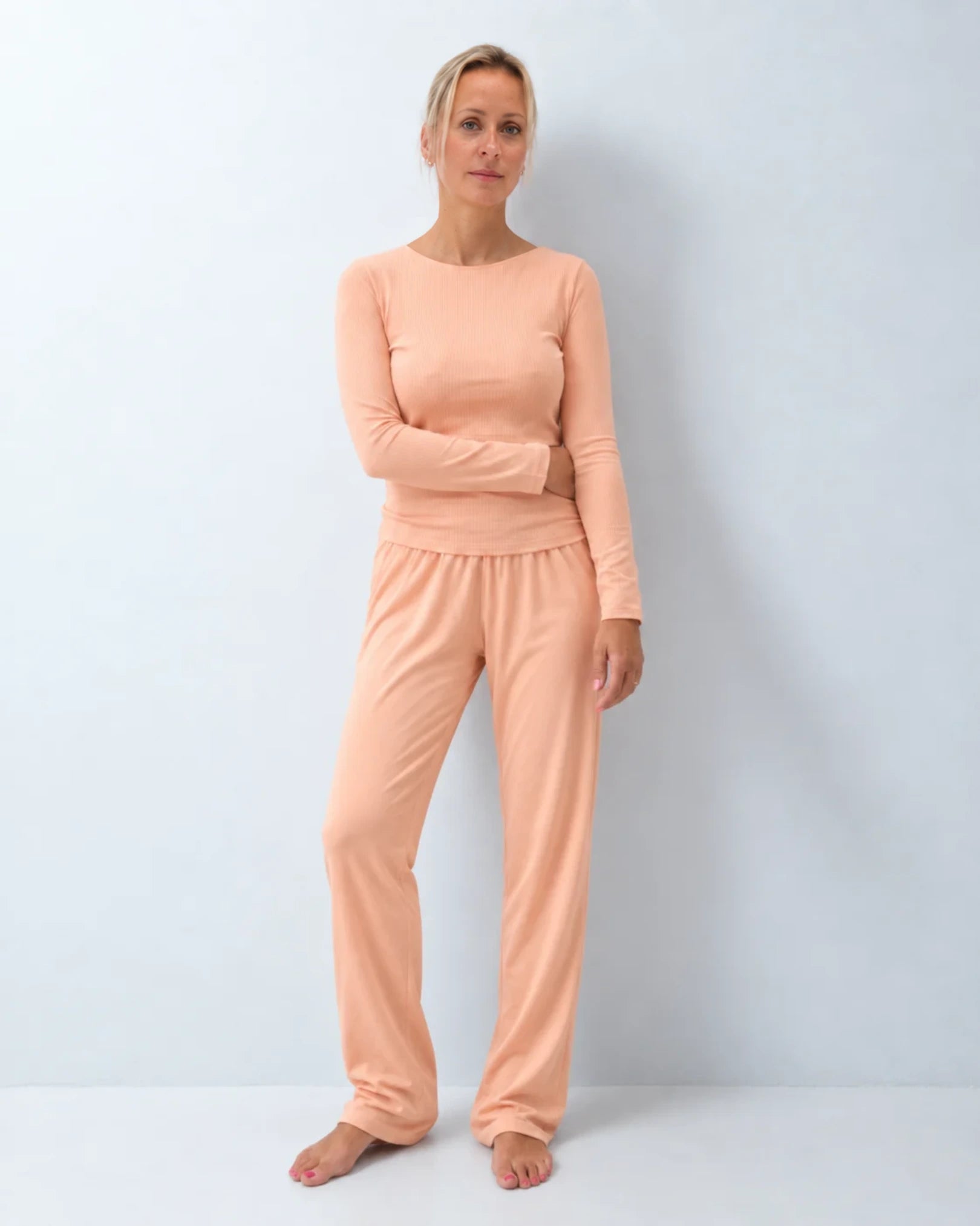 Vista delantera del pijama con top integrado camiseta canalé y pantalón recto color melocotón