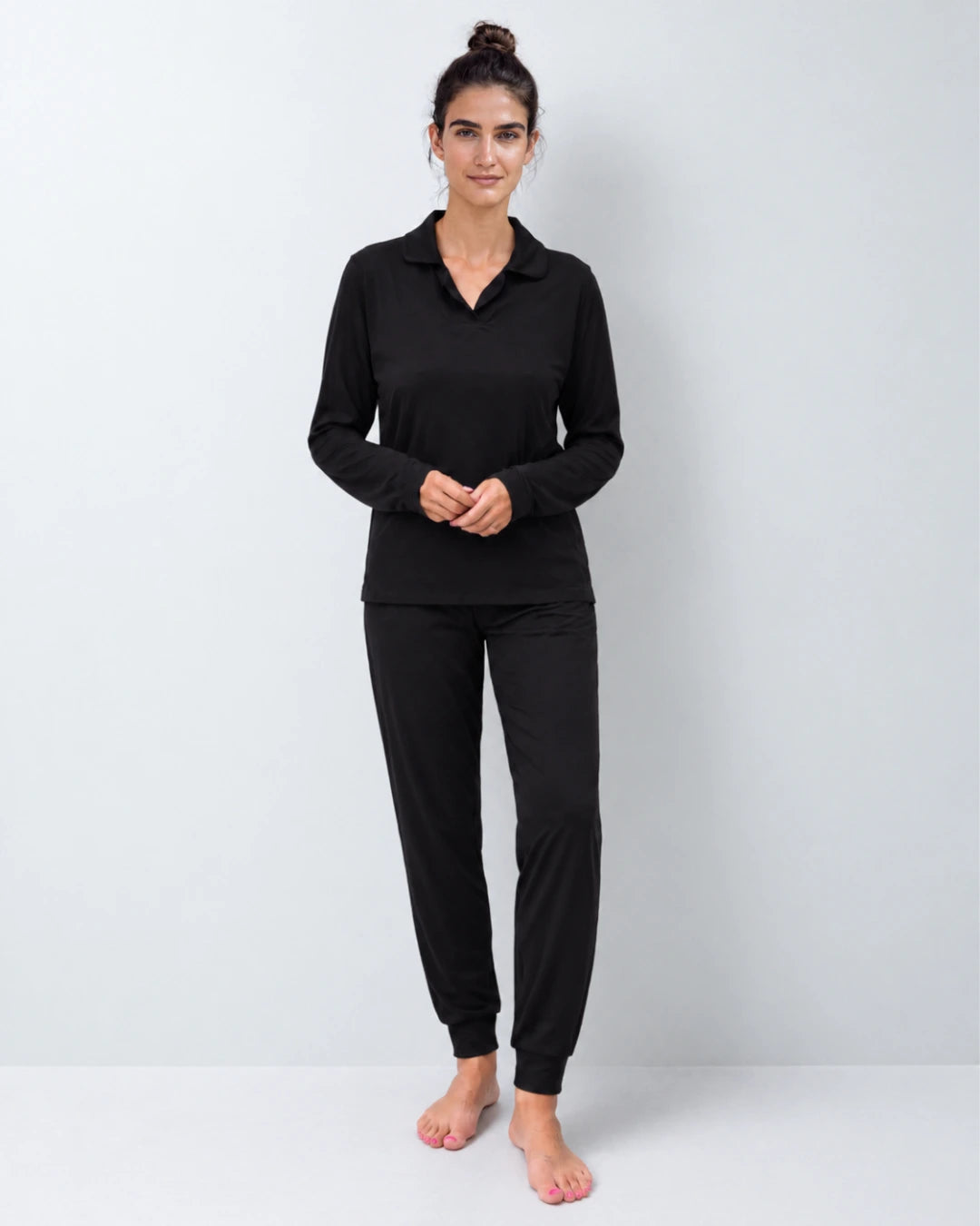 Vista delantera del pijama con top integrado cuello sastre y pantalón puño color negro