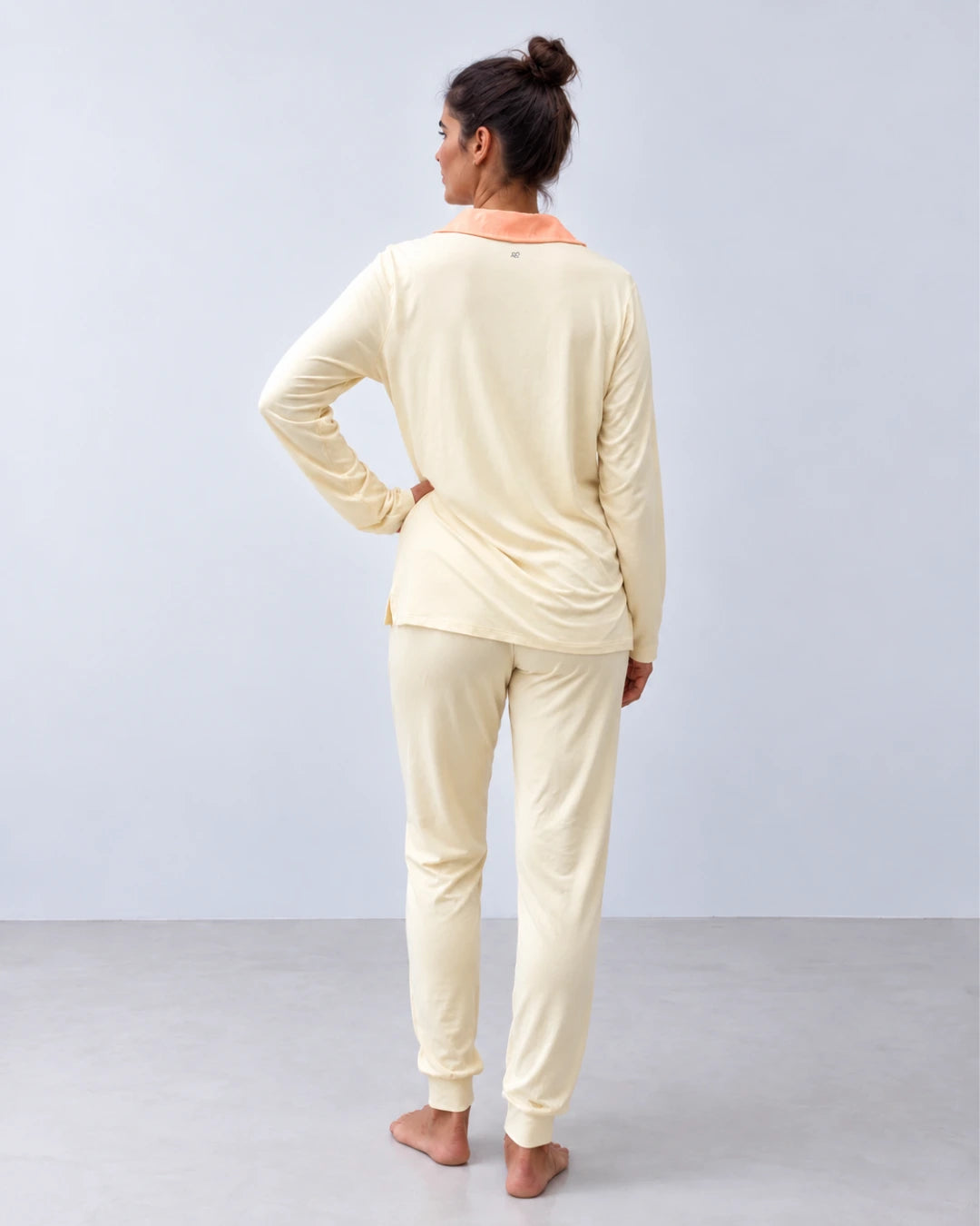 Vista trasera pijama con top integrado cuello sastre y pantalón puño color vainilla