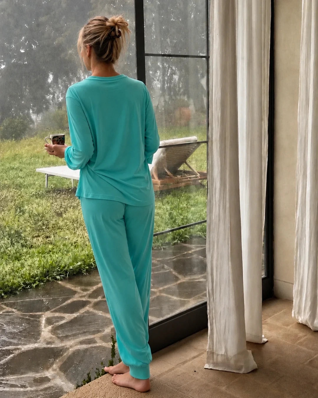 Modelo con pijama con top integrado camiseta cuello redondo color turquesa y pantalón puño